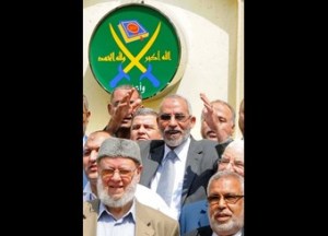 Egyptian Muslim brotherhood leader Mohammed Badie waves to journalists during a news conference to announce the head of the new Muslim Brotherhood party in Cairo